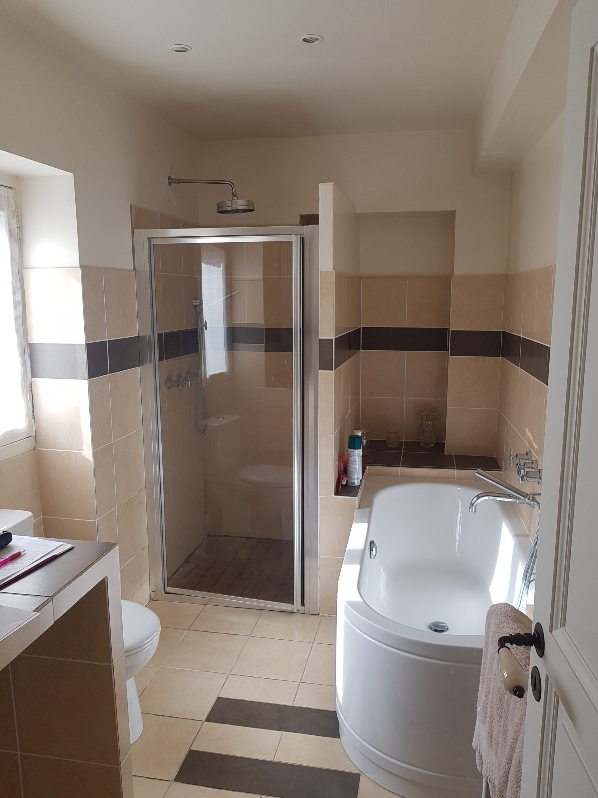 Photo d'une salle de bain avant rénovation avec une baignoire, douche à l'italienne et wc au sol sur un carrelage beige