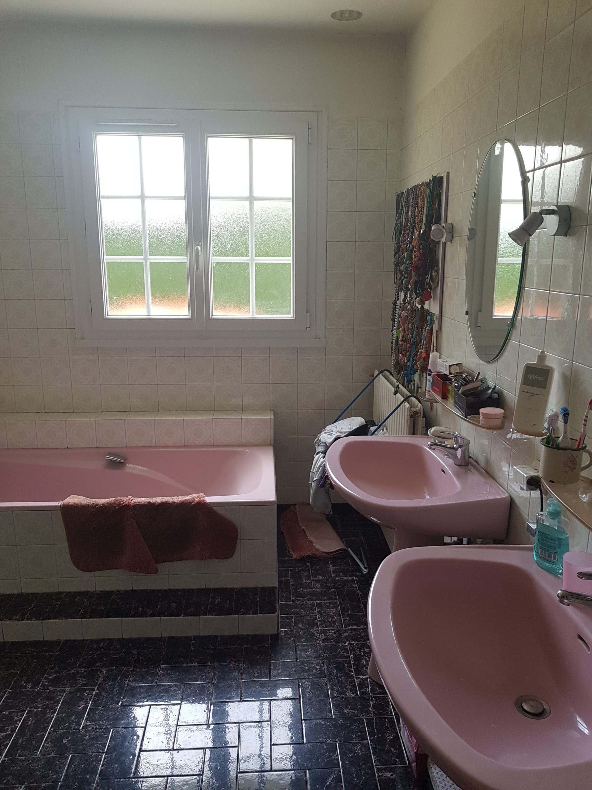 Photo d'une salle debain avant rénovation, deux vasques rose, carrelage bleu et faïence blanche