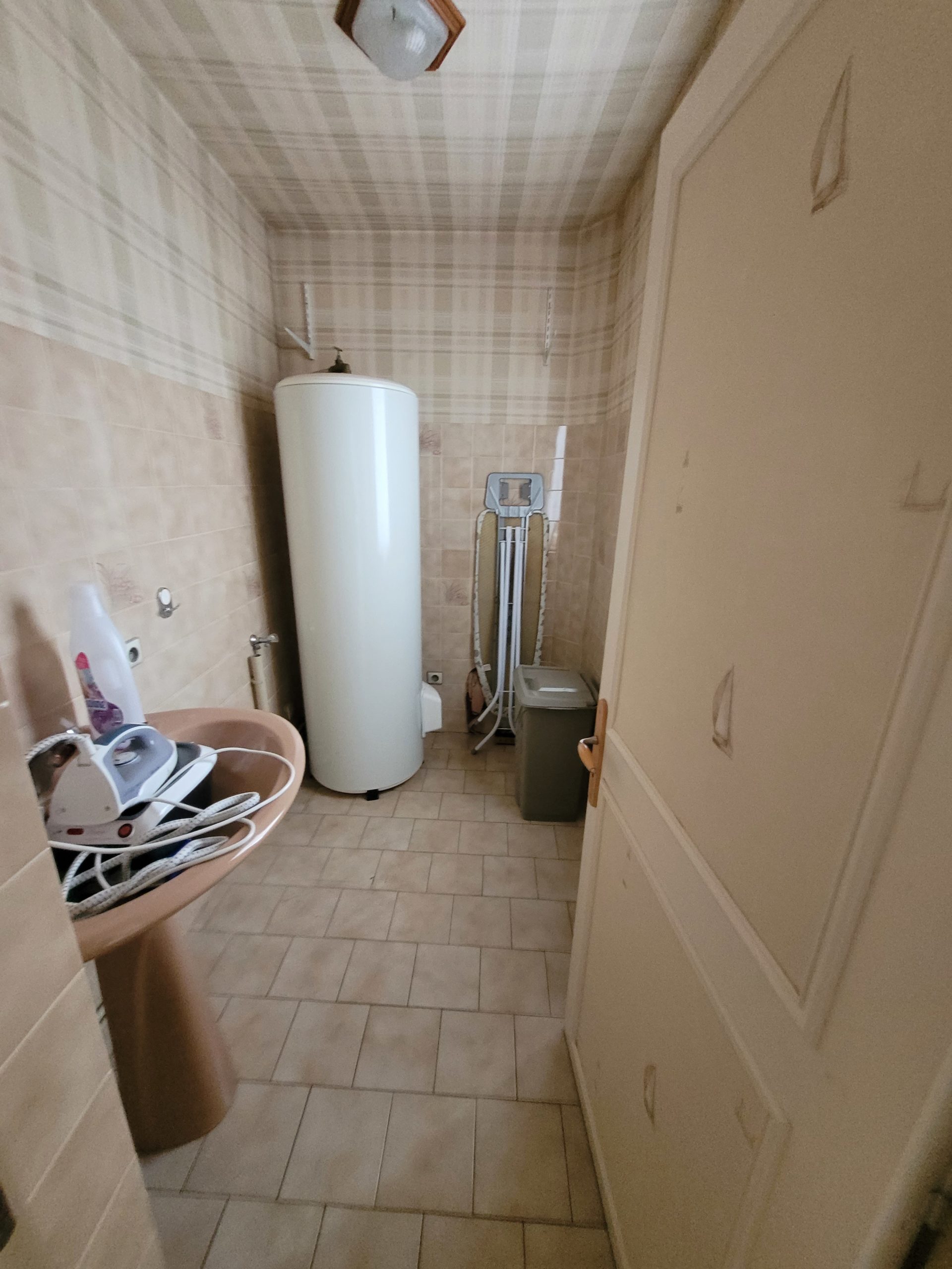 Photo d'une salle d'eau avant rénovation avec un lavabo rose, faïence et carrelage taupe