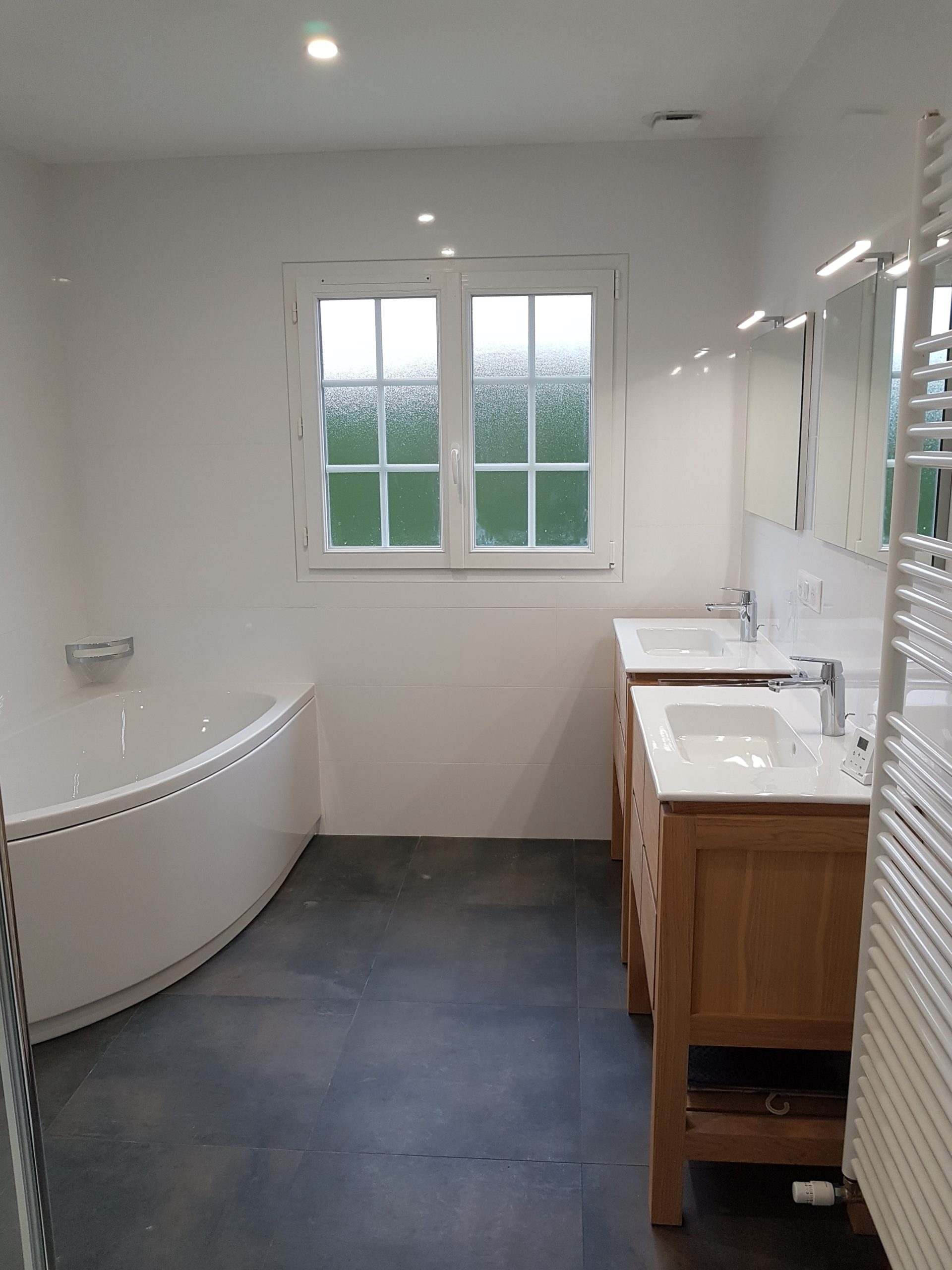 Photo d'une rénovation de salle de bain, deux vasques, carrelage gris, baignoire et faïence blanche