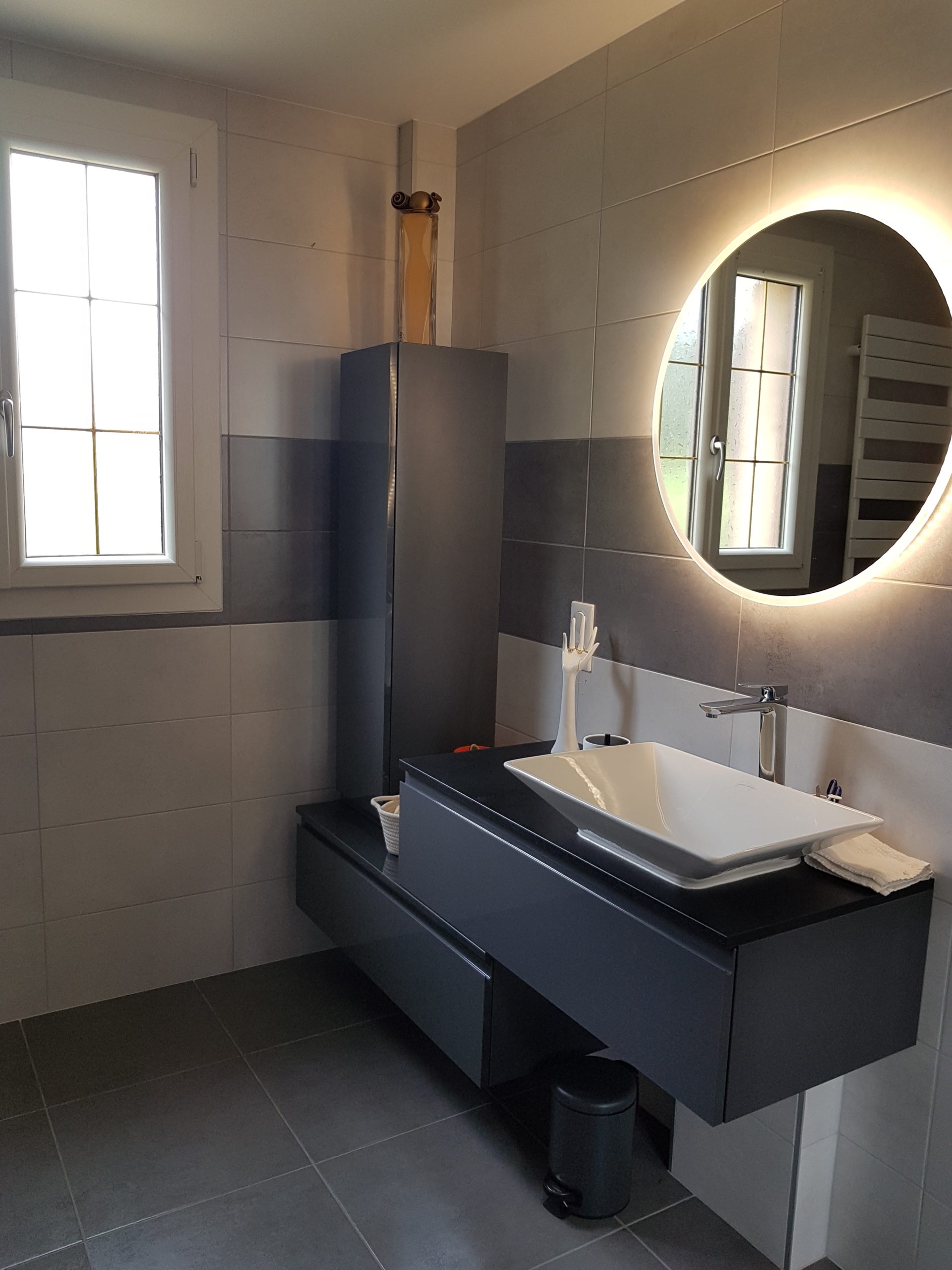 Photo d'une rénovation de salle de bain avec un miroir éclairé, un carrelage gris et de la faïence blanche
