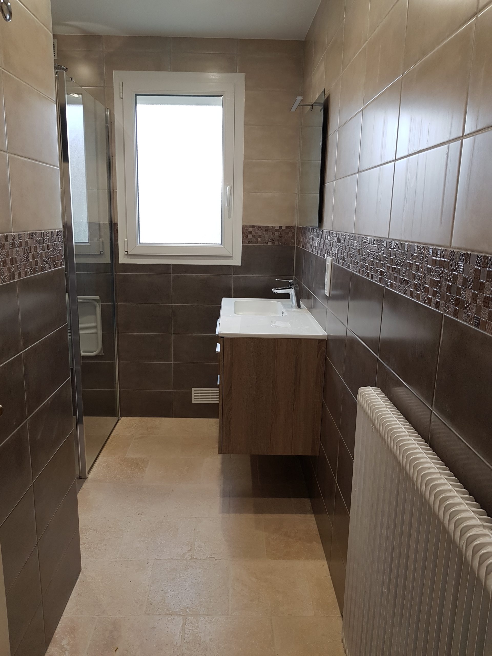 Photo d'une rénovation de salle de bain avec de la faïence marron, carrelage beige et une baignoire