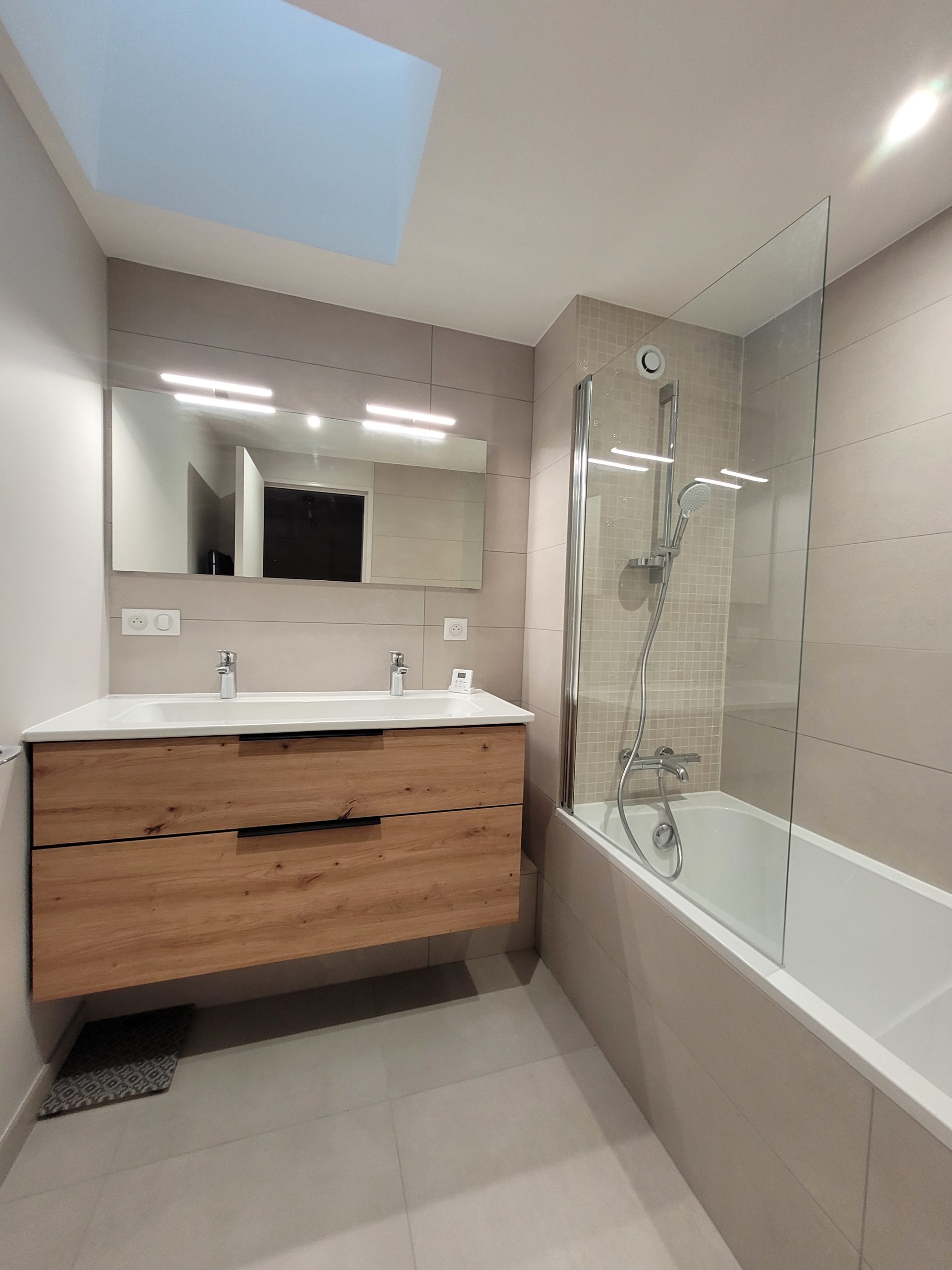 Photo d'une rénovation de salle de bain avec baignoire, double vasque et grande faïence couleur taupe