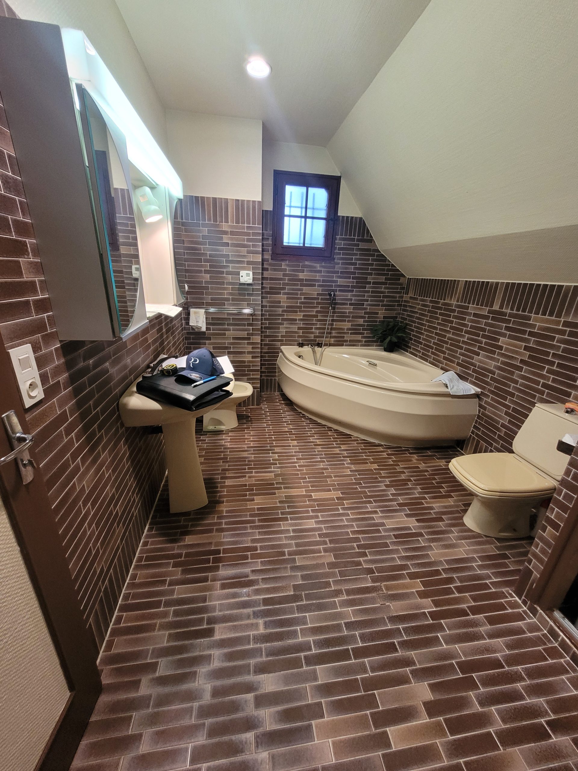 Photo d'une salle de bain avant rénovation de salle de bain avec faïence et carrelage marron