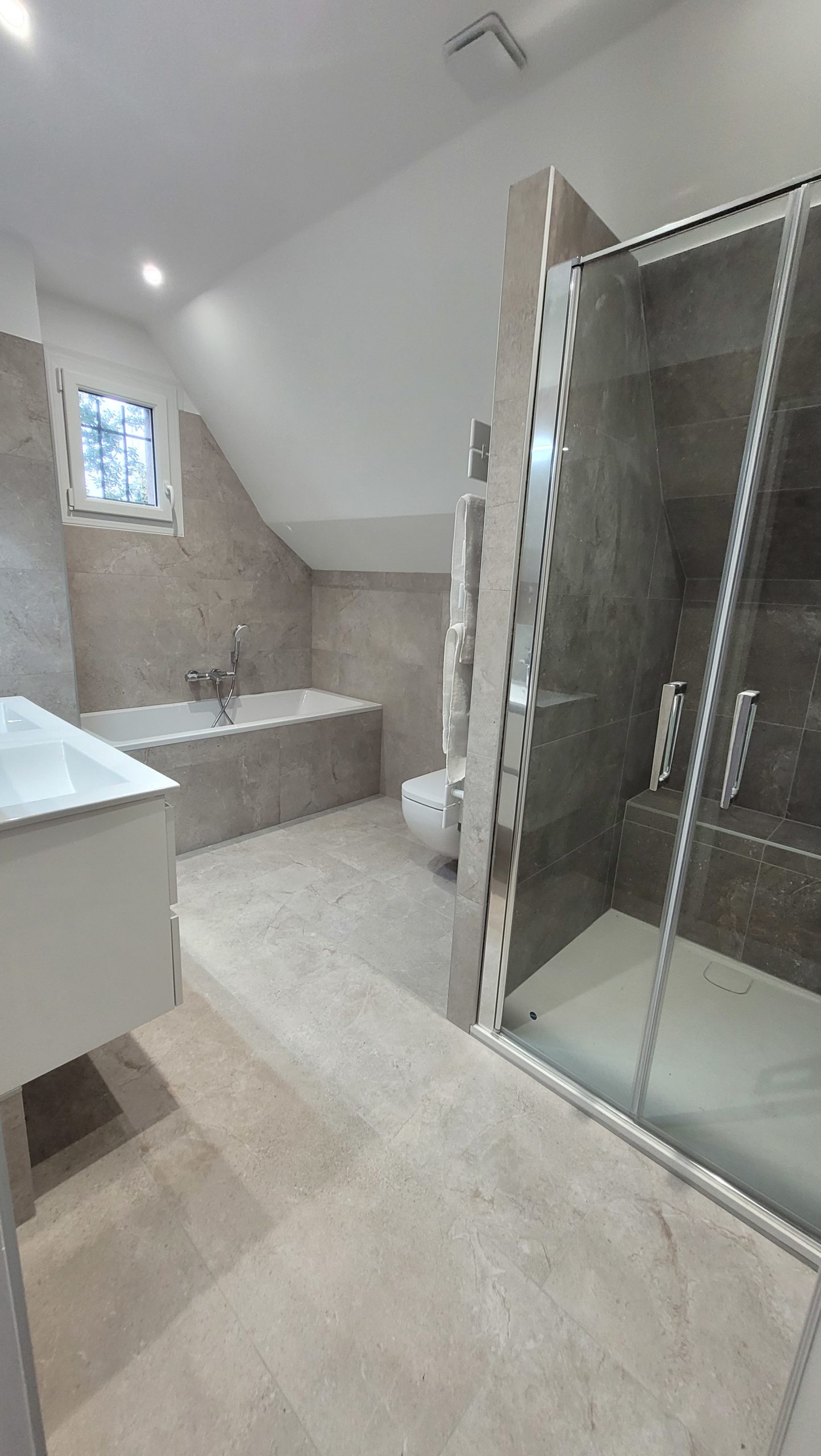 Photo d'une rénovation d'une salle de bain avec une baignoire, douche à l'italienne sur des nuances de gris